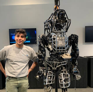 Akshay Jaitly — portrait beside a humanoid robot